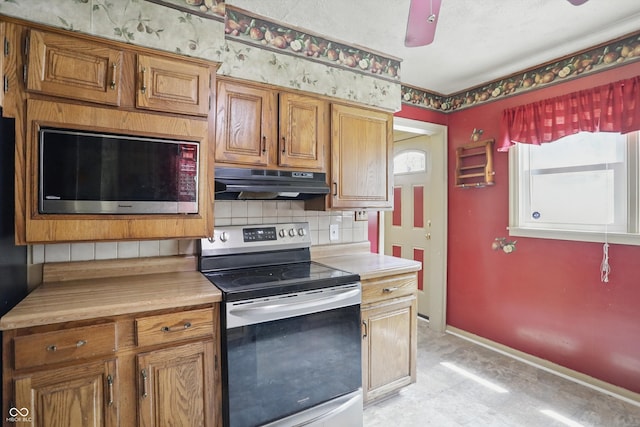 2905 N Warman Ave, Indianapolis, IN 46222 - kitchen with stainless steel appliances, under cabinet range hood, tasteful backsplash, brown cabinets, and a ceiling fan