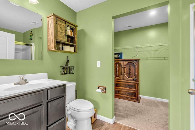 123 Campus Ln, Greenwood, IN 46143 - full bathroom featuring toilet, vanity, a shower with shower door, baseboards, and a walk in closet