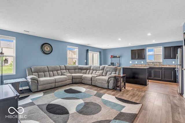 123 Campus Ln, Greenwood, IN 46143 - living room with light wood-style floors, a textured ceiling, and recessed lighting