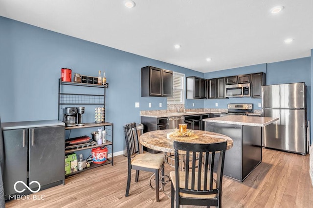 123 Campus Ln, Greenwood, IN 46143 - kitchen with stainless steel appliances, light wood-style floors, light countertops, a kitchen island, and recessed lighting