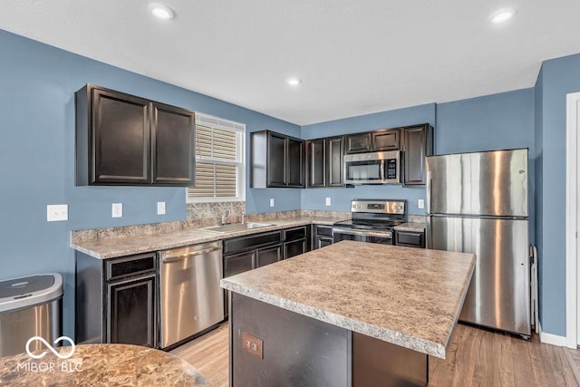 123 Campus Ln, Greenwood, IN 46143 - kitchen featuring stainless steel appliances, a sink, light wood finished floors, light countertops, and dark brown cabinets