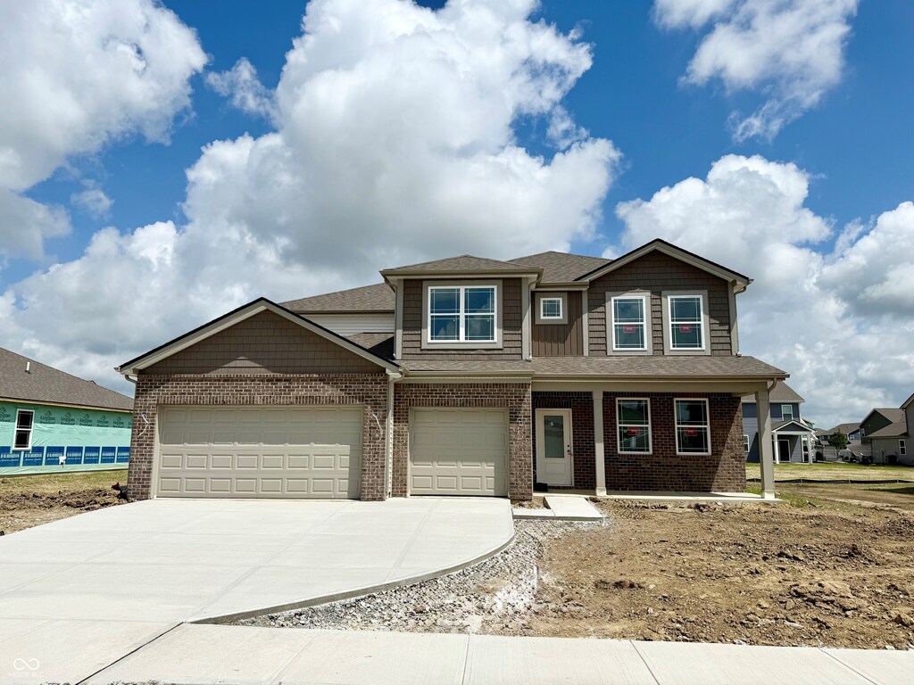 6032 Granby Dr, Whitestown, IN 46075 - view of front of property with driveway, brick siding, an attached garage, and a porch