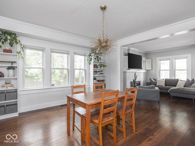 1617 E 52nd St, Indianapolis, IN 46205 - dining area featuring a fireplace, dark wood-style floors, ornamental molding, a chandelier, and baseboards