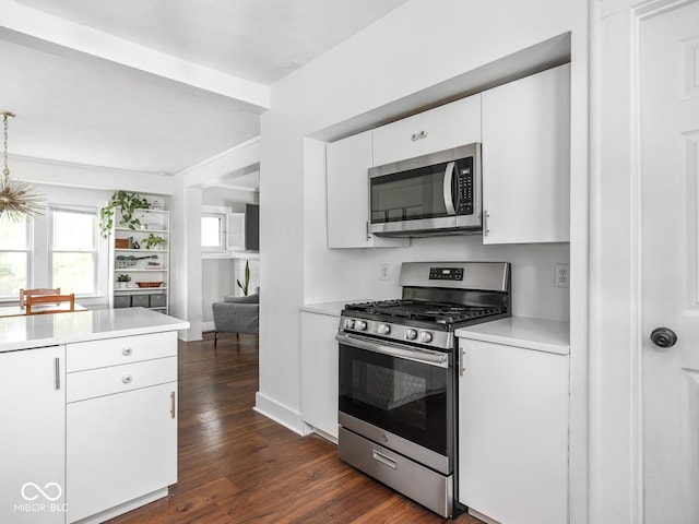 1617 E 52nd St, Indianapolis, IN 46205 - kitchen featuring appliances with stainless steel finishes, light countertops, dark wood finished floors, white cabinets, and baseboards