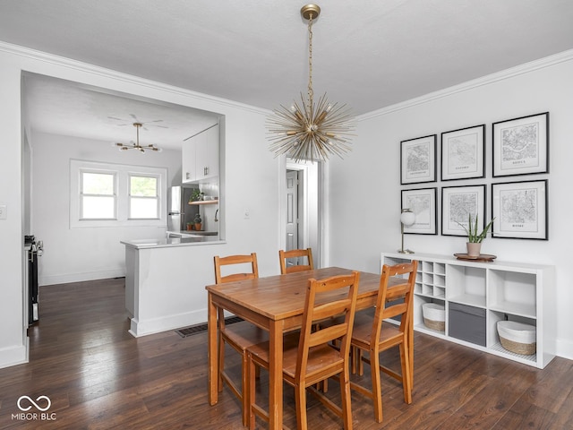 1617 E 52nd St, Indianapolis, IN 46205 - dining space featuring a chandelier, dark wood-type flooring, crown molding, and baseboards