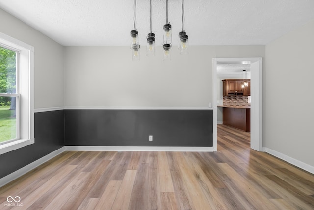 12383 S 25 W, Columbus, IN 47201 - unfurnished dining area featuring wood finished floors, a textured ceiling, and baseboards