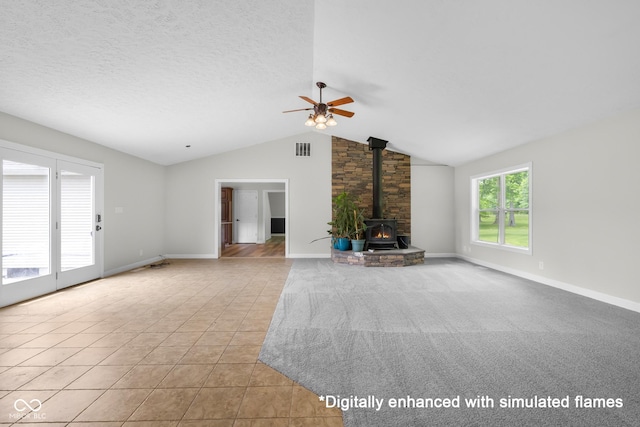 12383 S 25 W, Columbus, IN 47201 - unfurnished living room featuring a wood stove, a ceiling fan, tile patterned flooring, lofted ceiling, and baseboards
