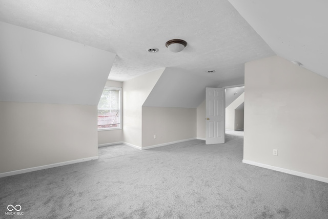 12383 S 25 W, Columbus, IN 47201 - additional living space with lofted ceiling, a textured ceiling, carpet flooring, and baseboards