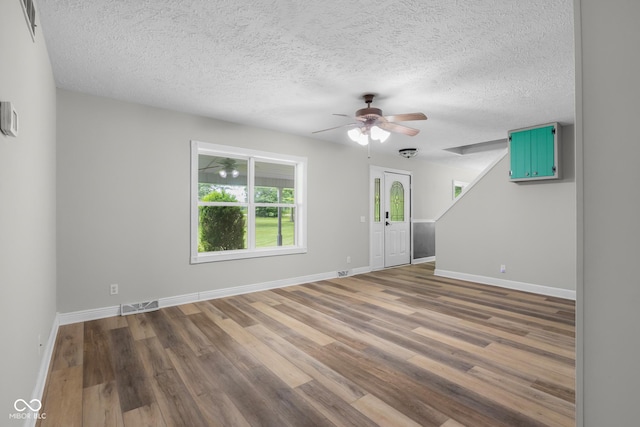 12383 S 25 W, Columbus, IN 47201 - unfurnished living room with ceiling fan, a textured ceiling, wood finished floors, and baseboards