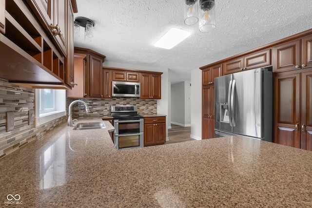 12383 S 25 W, Columbus, IN 47201 - kitchen with appliances with stainless steel finishes, a sink, tasteful backsplash, light stone countertops, and a textured ceiling