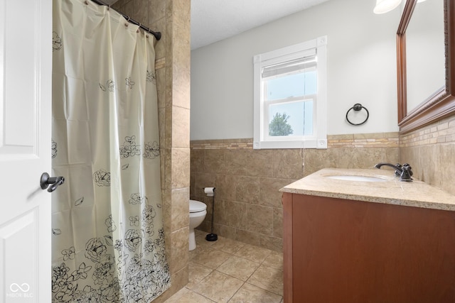 12383 S 25 W, Columbus, IN 47201 - full bath featuring tile walls, vanity, toilet, tile patterned floors, and wainscoting