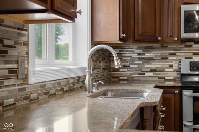 12383 S 25 W, Columbus, IN 47201 - kitchen featuring appliances with stainless steel finishes, a sink, tasteful backsplash, and light stone counters