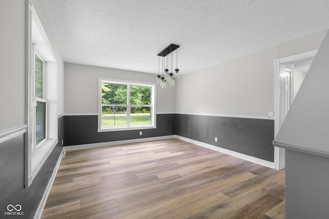 12383 S 25 W, Columbus, IN 47201 - unfurnished dining area with wood finished floors, a textured ceiling, a chandelier, and baseboards