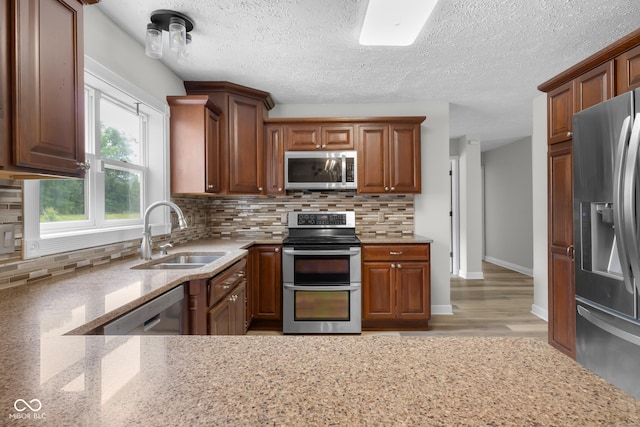 12383 S 25 W, Columbus, IN 47201 - kitchen featuring appliances with stainless steel finishes, a sink, light stone counters, decorative backsplash, and a textured ceiling
