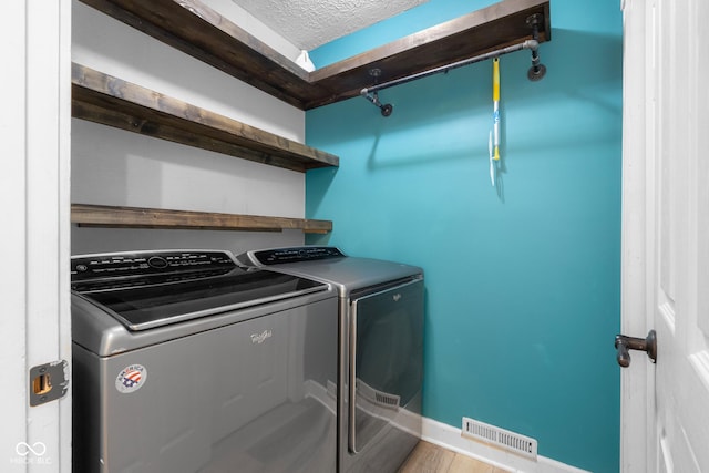 12383 S 25 W, Columbus, IN 47201 - washroom featuring washer and dryer, baseboards, a textured ceiling, and wood finished floors