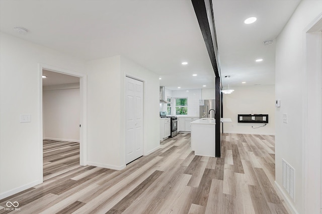 233 N Devon Ave, Indianapolis, IN 46219 - hall featuring light wood-type flooring, recessed lighting, a sink, and baseboards