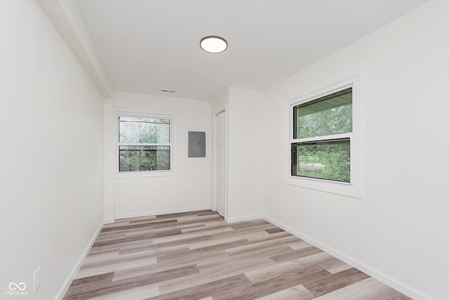 233 N Devon Ave, Indianapolis, IN 46219 - unfurnished room with electric panel, healthy amount of natural light, light wood-style flooring, and baseboards