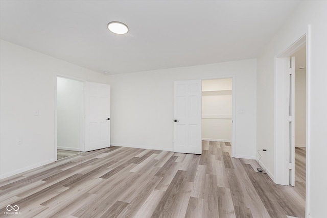 233 N Devon Ave, Indianapolis, IN 46219 - unfurnished bedroom featuring light wood-style flooring, baseboards, and a closet