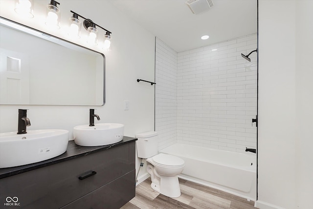 233 N Devon Ave, Indianapolis, IN 46219 - bathroom with wood finished floors, double vanity, toilet, and shower / washtub combination