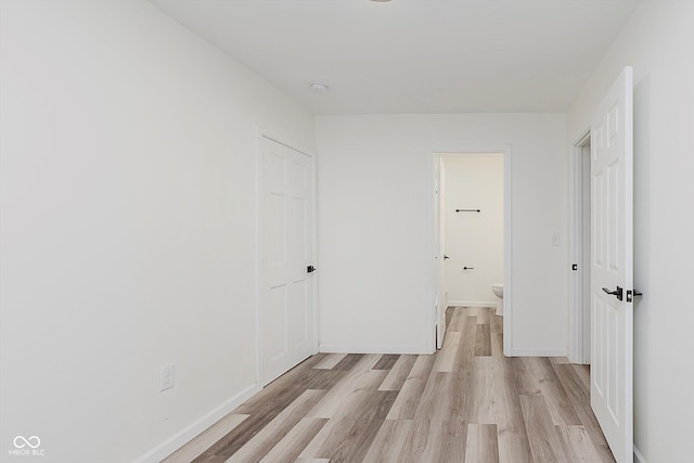 233 N Devon Ave, Indianapolis, IN 46219 - unfurnished bedroom featuring light wood finished floors, baseboards, and ensuite bath