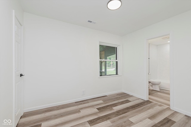233 N Devon Ave, Indianapolis, IN 46219 - unfurnished bedroom featuring light wood-style flooring, baseboards, and ensuite bathroom