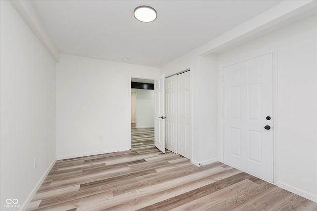 233 N Devon Ave, Indianapolis, IN 46219 - unfurnished bedroom with light wood-style floors, a closet, and baseboards