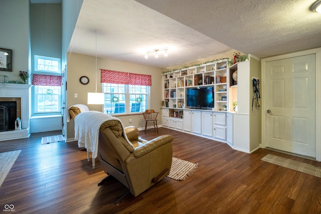 1052 Barley Cir, Carmel, IN 46032 - living room featuring a textured ceiling, dark wood-style floors, a tile fireplace, and baseboards