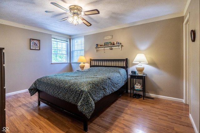 1052 Barley Cir, Carmel, IN 46032 - bedroom featuring wood finished floors, baseboards, a textured ceiling, and a ceiling fan
