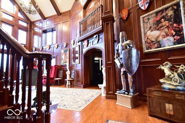 6412 Fall Creek Rd, Indianapolis, IN 46220 - foyer featuring a decorative wall, arched walkways, light wood-type flooring, a chandelier, and high vaulted ceiling