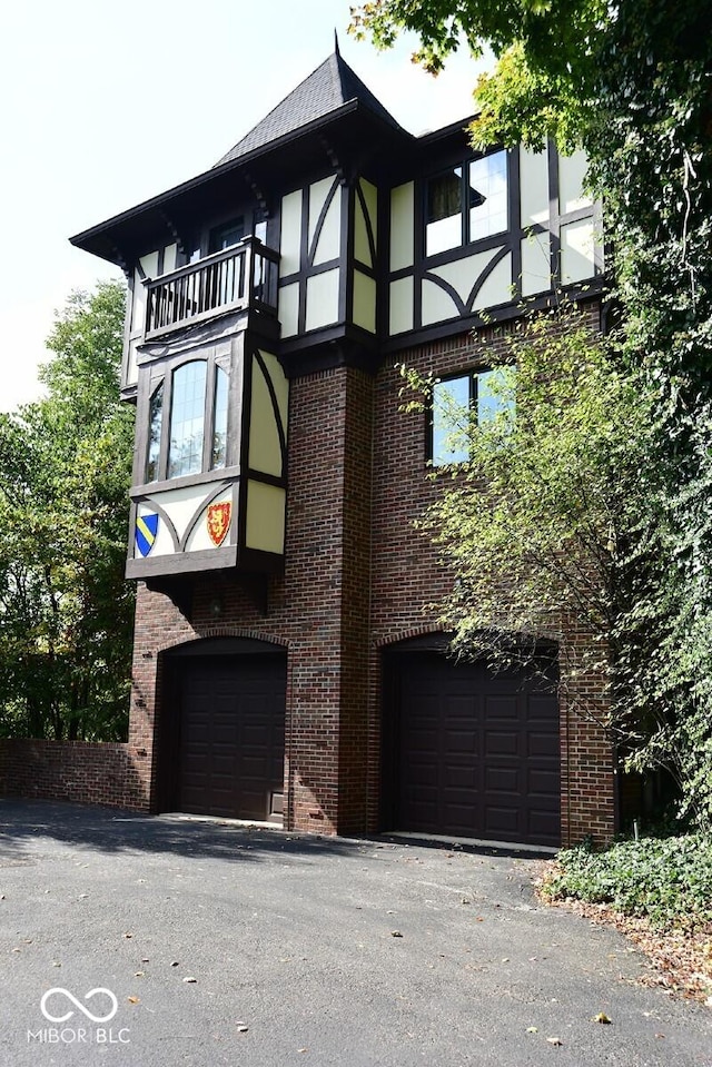 6412 Fall Creek Rd, Indianapolis, IN 46220 - view of front of property with a garage, brick siding, a balcony, and stucco siding