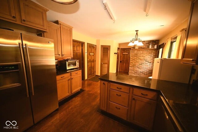6412 Fall Creek Rd, Indianapolis, IN 46220 - kitchen featuring stainless steel fridge, dark countertops, dark wood-type flooring, a peninsula, and a chandelier