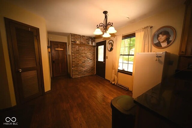 6412 Fall Creek Rd, Indianapolis, IN 46220 - foyer entrance featuring a chandelier, wood finished floors, and brick wall