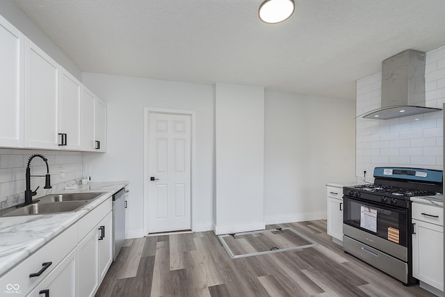 2531 E Brookside Ave, Indianapolis, IN 46218 - kitchen featuring stainless steel appliances, a sink, wall chimney range hood, backsplash, and a textured ceiling