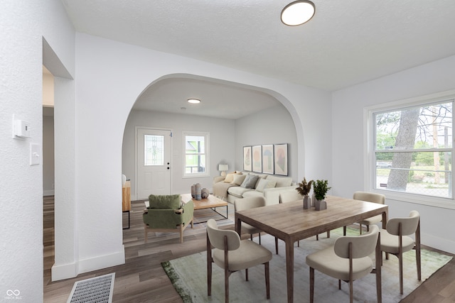 2531 E Brookside Ave, Indianapolis, IN 46218 - dining room with arched walkways, wood finished floors, and baseboards