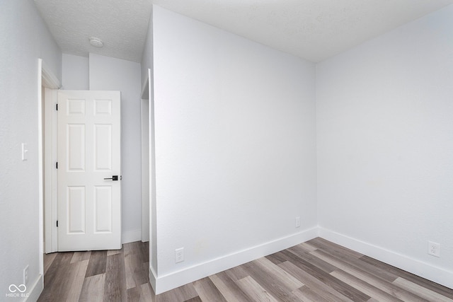 2531 E Brookside Ave, Indianapolis, IN 46218 - unfurnished room featuring wood finished floors, baseboards, a textured ceiling, and a smoke detector