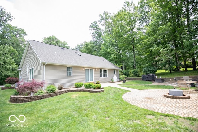 495 Persimmon Dr, North Vernon, IN 47265 - back of property featuring a fire pit, a patio area, and a lawn