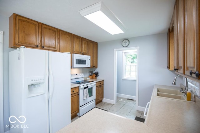 495 Persimmon Dr, North Vernon, IN 47265 - kitchen with white appliances, a sink, brown cabinets, and light tile patterned floors