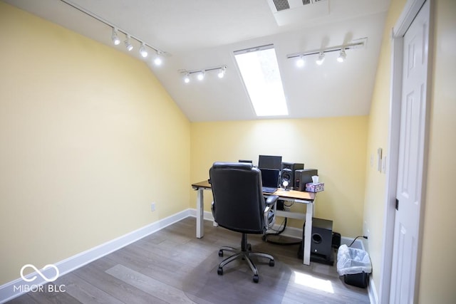 495 Persimmon Dr, North Vernon, IN 47265 - office featuring track lighting, lofted ceiling, wood finished floors, baseboards, and a skylight