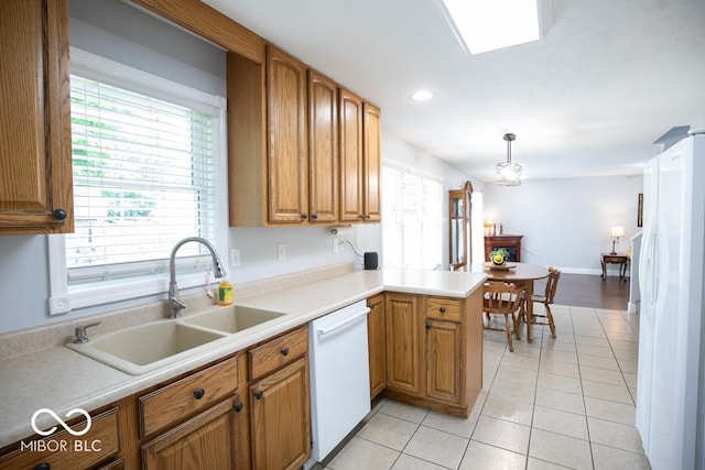 495 Persimmon Dr, North Vernon, IN 47265 - kitchen featuring white appliances, a sink, light tile patterned floors, brown cabinets, and a peninsula