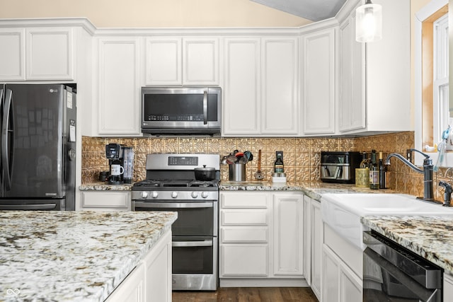 5730 S 50 W, Trafalgar, IN 46181 - kitchen with stainless steel appliances, white cabinetry, a sink, tasteful backsplash, and vaulted ceiling