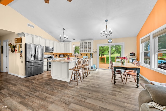 5730 S 50 W, Trafalgar, IN 46181 - kitchen with appliances with stainless steel finishes, a chandelier, vaulted ceiling, tasteful backsplash, and dark wood-type flooring