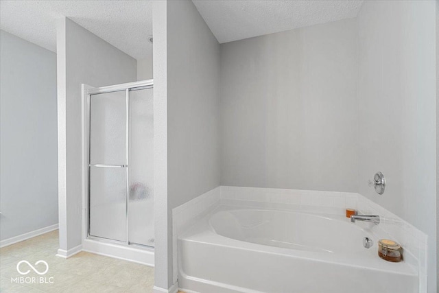 12624 Majestic Way, Fishers, IN 46037 - bathroom with a textured ceiling, a bath, a stall shower, baseboards, and tile patterned floors