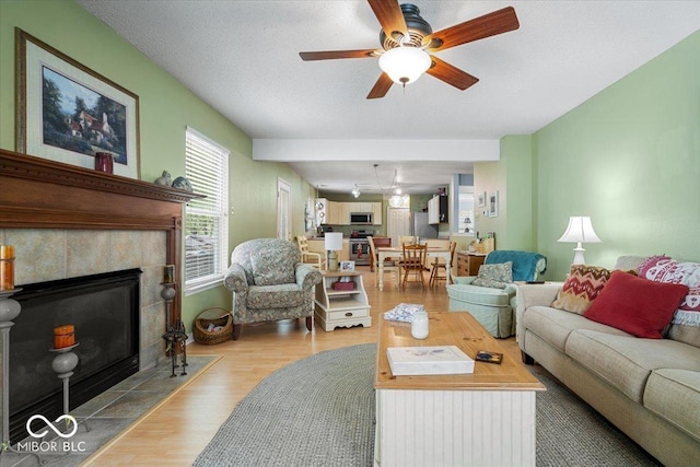 12624 Majestic Way, Fishers, IN 46037 - living area featuring wood finished floors, a ceiling fan, and a fireplace