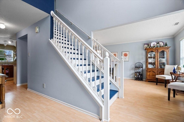 12624 Majestic Way, Fishers, IN 46037 - stairs featuring a textured ceiling, wood finished floors, and baseboards
