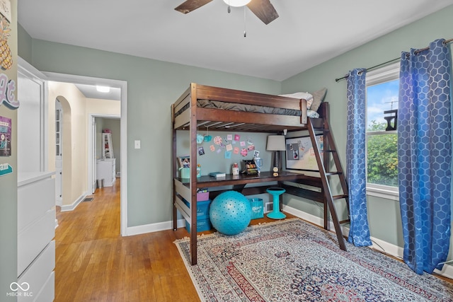 2645 Washington St, Columbus, IN 47201 - bedroom with wood finished floors, baseboards, a ceiling fan, and arched walkways