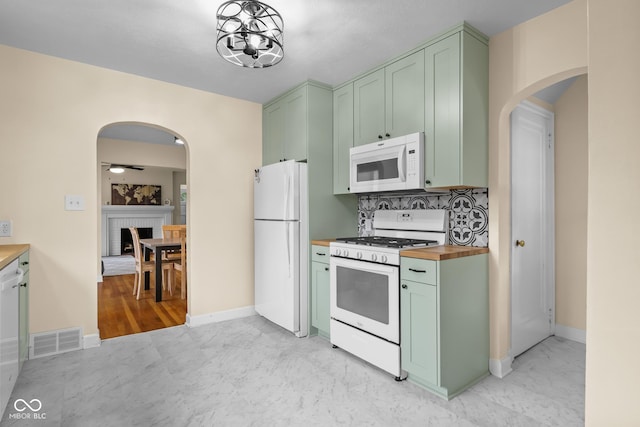 2645 Washington St, Columbus, IN 47201 - kitchen with white appliances, green cabinetry, butcher block counters, and arched walkways