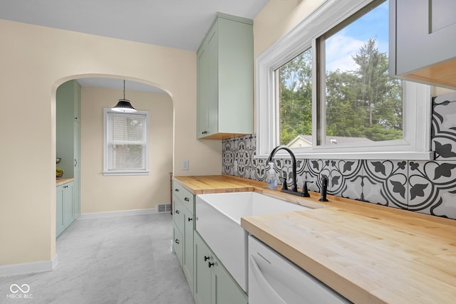 2645 Washington St, Columbus, IN 47201 - kitchen with wood counters, green cabinets, arched walkways, decorative backsplash, and hanging light fixtures