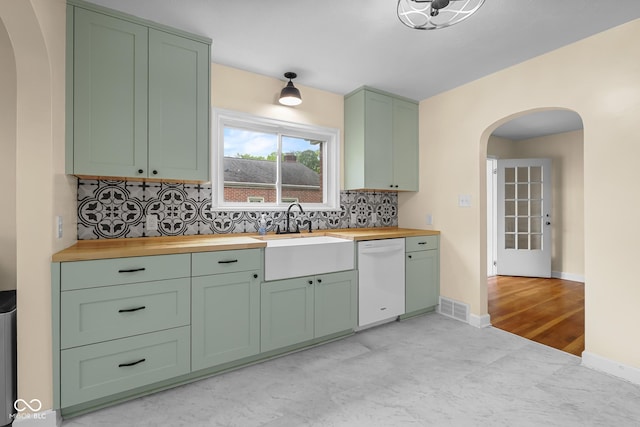 2645 Washington St, Columbus, IN 47201 - kitchen featuring green cabinetry, wooden counters, dishwasher, arched walkways, and a sink