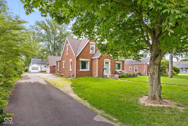 2645 Washington St, Columbus, IN 47201 - bungalow with driveway, brick siding, a front yard, and an outbuilding