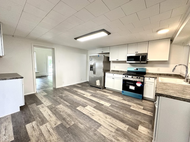 106 S Hancock St, Waynetown, IN 47990 - kitchen with appliances with stainless steel finishes, a sink, dark countertops, and dark wood-style flooring